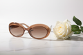 Fendi FF oval sunglasses top down view with white rose on marble